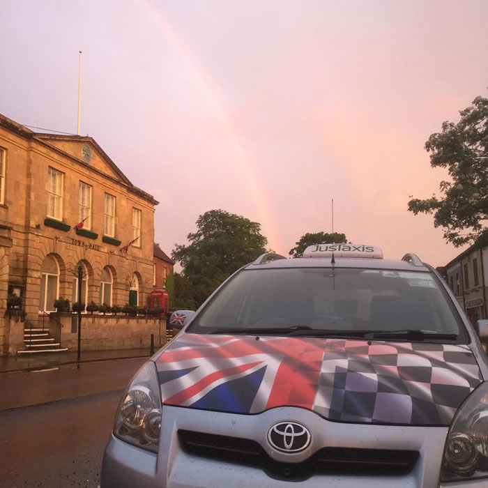 JusTaxis Taxi picking up at Glastonbury Town Hall in Somerset